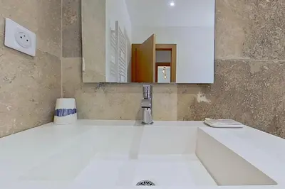 a bathroom with a white sink and a mirror at Bergeries de l'Argiale - ARGHJALE - hôtel in Figari