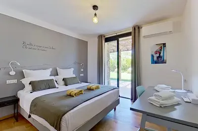 a bedroom with a large bed and a desk and a table at Bergeries de l'Argiale - ARGHJALE - hôtel in Figari