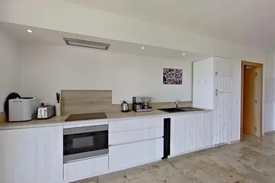a kitchen with white cabinets and a counter top at Bergeries de l'Argiale - ARGHJALE - hôtel in Figari