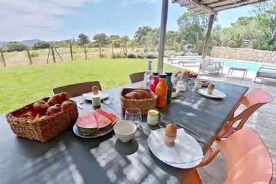 a table with food and baskets of bread on it at Bergeries de l'Argiale - ARGHJALE - hôtel in Figari