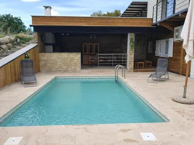 a swimming pool with two chairs and a house at Isula Bella in Prunelli-di-Fiumorbo