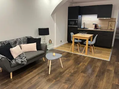 a living room with a couch and a table and a kitchen at Marina'home in Ajaccio