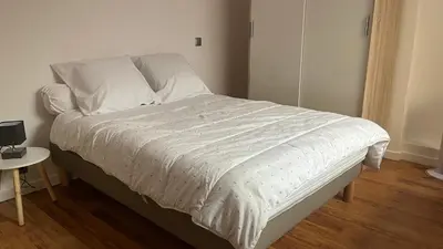 a bed with a white comforter in a bedroom at Marina'home in Ajaccio