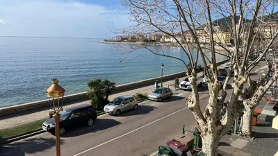 a street with cars parked on a road next to the water at Marina'home in Ajaccio