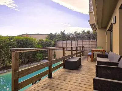 a deck with a pool and a table and chairs at Villa di Favona 4 chambres piscine privée in Conca