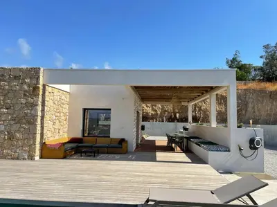 a living area of a house with a stone wall at Villa Alandra in Pietrosella