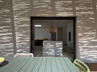 a dining room with a table and a refrigerator at Villa Alandra in Pietrosella