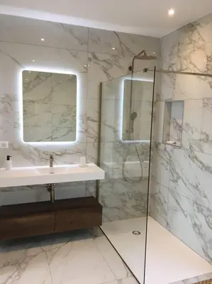 a bathroom with a sink and a shower with a mirror at Villa Alandra in Pietrosella