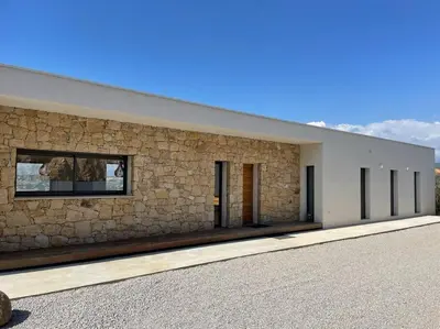 a building with a stone wall and a building at Villa Alandra in Pietrosella