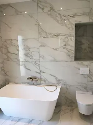 a white bathroom with a tub and a toilet at Villa Alandra in Pietrosella