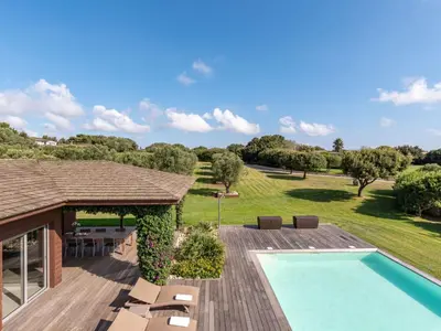 an outdoor deck with a swimming pool and a house at Holiday Home Villa Lavezzi by Interhome in Bonifacio