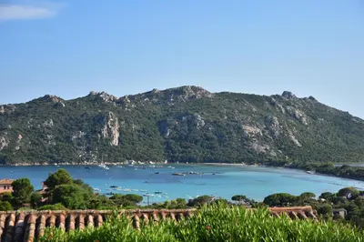 a view of a bay with mountains in the background at Hôtel Alivi Di Santa Giulia in Porto-Vecchio
