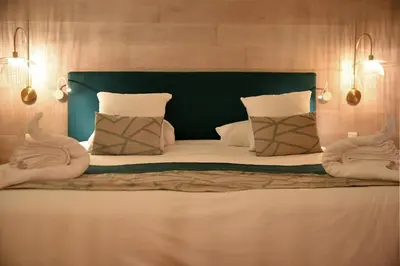 a large bed with a green headboard and pillows at Hôtel Alivi Di Santa Giulia in Porto-Vecchio