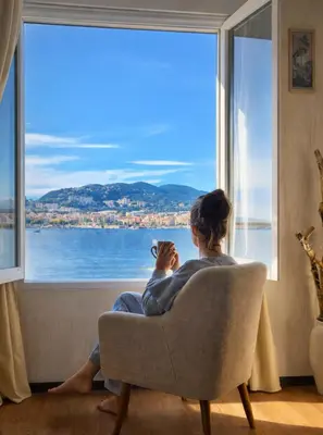 a living room with a couch and a window at Appartement entier, climatisé, vue mer in Ajaccio