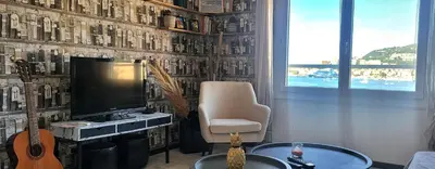 a kitchen with a table with chairs and a window at Appartement entier, climatisé, vue mer in Ajaccio
