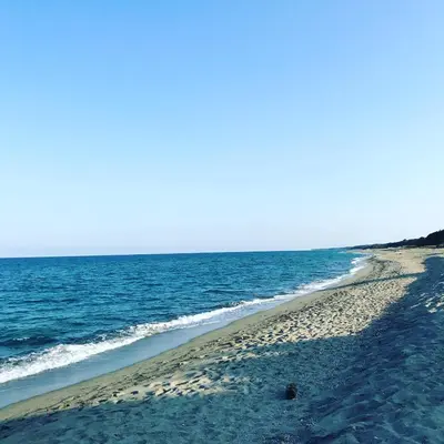 an empty beach with the ocean in the background at Maison pieds dans l eau avec piscine et clim in Linguizzetta