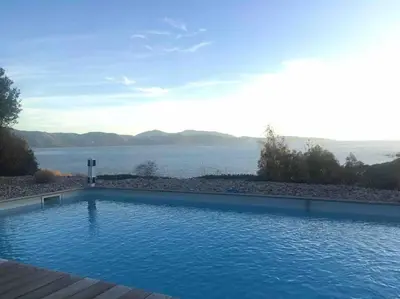 a large swimming pool with a view of the water at Casa Turrigiani in Sagone