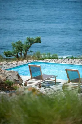 three lounge chairs sitting next to a swimming pool at Casa Turrigiani in Sagone