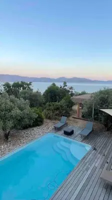 a large blue swimming pool on a wooden deck at Casa Turrigiani in Sagone