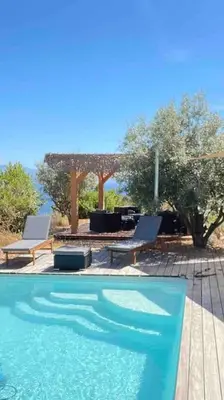 a swimming pool with two chairs and a table at Casa Turrigiani in Sagone