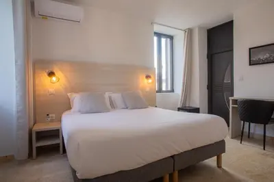 a bedroom with a large white bed and a window at A PIANARELLA in San-Gavino-di-Carbini