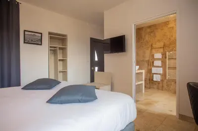 a bedroom with a large white bed with blue pillows at A PIANARELLA in San-Gavino-di-Carbini