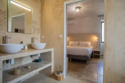 a bedroom with a bed and a sink and a mirror at A PIANARELLA in San-Gavino-di-Carbini