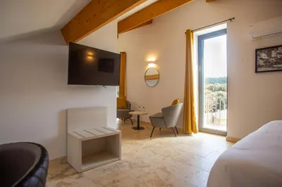 a bedroom with a bed and a table and a window at A PIANARELLA in San-Gavino-di-Carbini