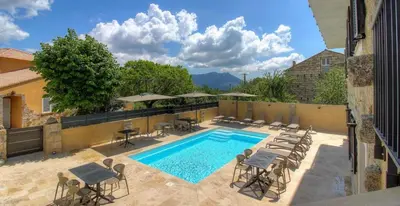 a swimming pool with chairs and umbrellas at A PIANARELLA in San-Gavino-di-Carbini