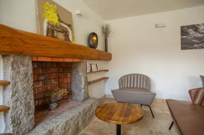 a living room with a brick fireplace and a chair at A PIANARELLA in San-Gavino-di-Carbini