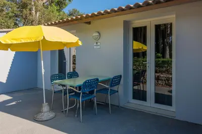 a table and chairs with a yellow umbrella on a patio at Residence Club Marina Viva in Porticcio