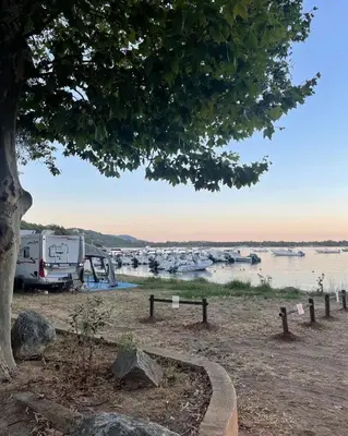 a tent and a table and chairs in a field at Camping La Baie des Voiles in Porto-Vecchio