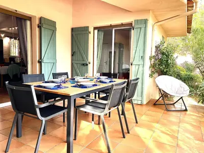 a dining table and chairs in a room with a patio at Palombaggia in Porto-Vecchio