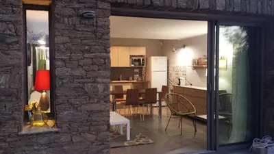 a living room and a kitchen with a dining room at U Muzzelo in Oletta