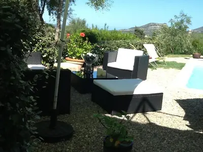 a patio with chairs and a table and a pool at U Muzzelo in Oletta