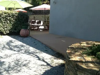 a patio with chairs and umbrellas and a table and chairs at U Muzzelo in Oletta