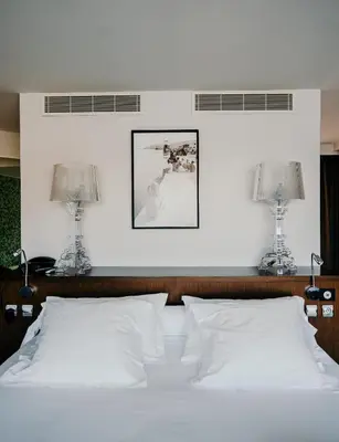 a bedroom with a white bed with two lamps at Le Golfe in Porto Pollo