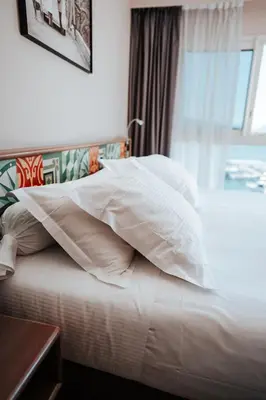 a bedroom with a bed with white pillows and a window at Le Golfe in Porto Pollo