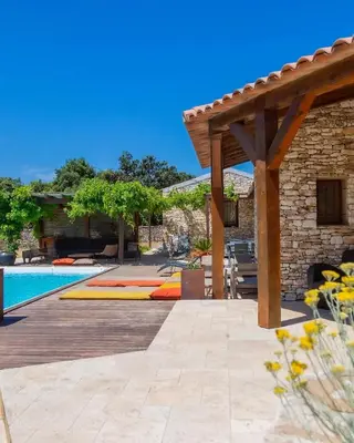 a patio with a pool and a wooden pergola at Villa SoleLuna chambre Jeanne in Bonifacio