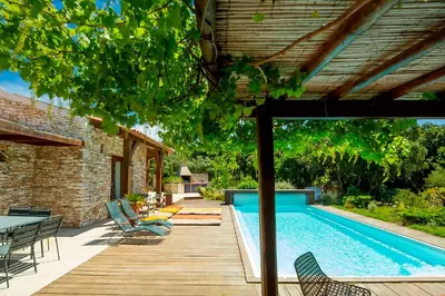 a swimming pool with chairs and a table next to a house at Villa SoleLuna chambre Jeanne in Bonifacio