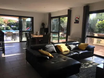 a living room with a leather couch and a table at villa standing piscine chauffée privée in Sainte-Lucie de Porto-Vecchio