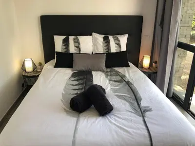 a bed with two black hats on it at villa standing piscine chauffée privée in Sainte-Lucie de Porto-Vecchio