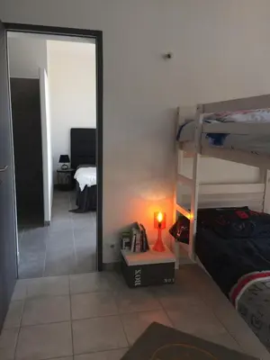 a bedroom with two bunk beds and a mirror at villa standing piscine chauffée privée in Sainte-Lucie de Porto-Vecchio