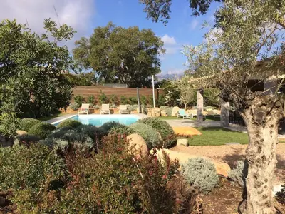 a garden with a swimming pool and some bushes at villa standing piscine chauffée privée in Sainte-Lucie de Porto-Vecchio
