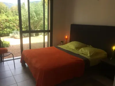 a bedroom with a bed with a large window at villa standing piscine chauffée privée in Sainte-Lucie de Porto-Vecchio