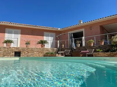 a swimming pool in front of a house at Villa BRIMI in Ghisonaccia