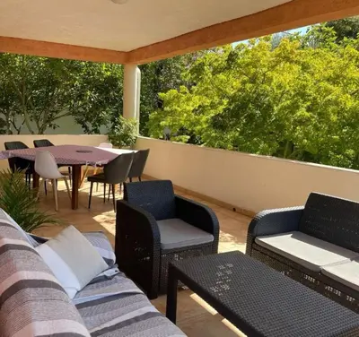 a patio with furniture and a table and chairs at Villa BRIMI in Ghisonaccia