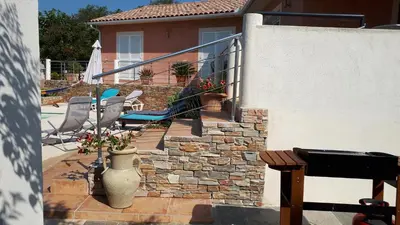 a patio with a staircase and a vase with flowers at Villa BRIMI in Ghisonaccia