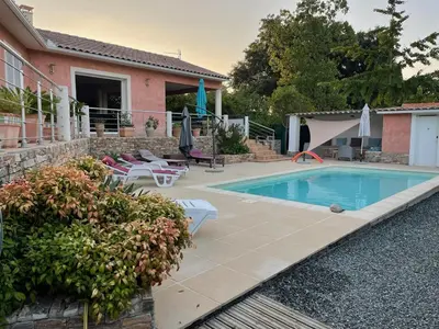 a swimming pool in front of a house at Villa BRIMI in Ghisonaccia