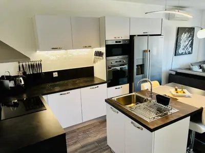 a kitchen with white cabinets and a black counter top at Casa Petra SALGA in Corte